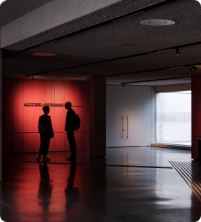 silueta de dos personas conversando sobre un fondo rojo y una entrada